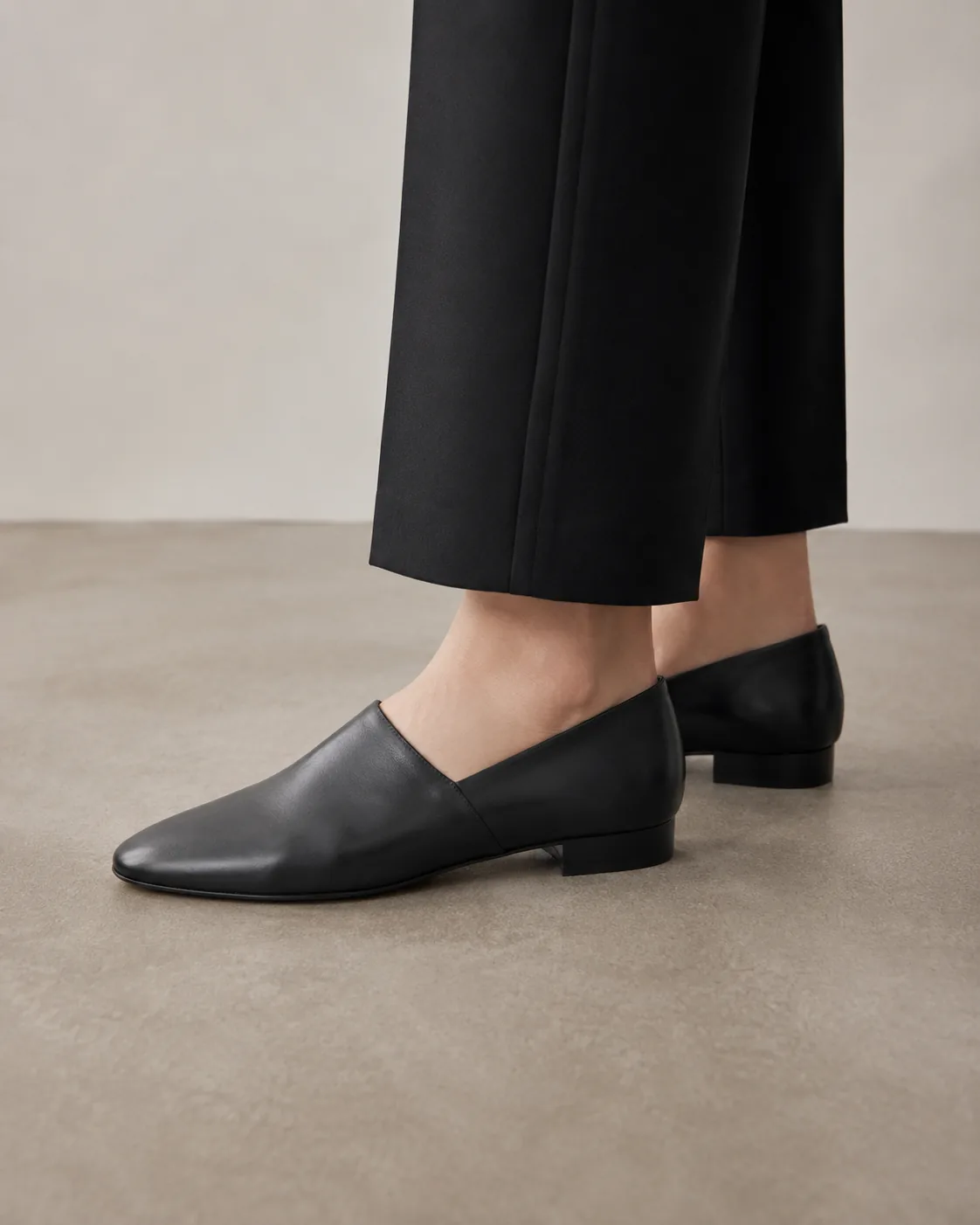 Black leather loafers with tailored black trousers